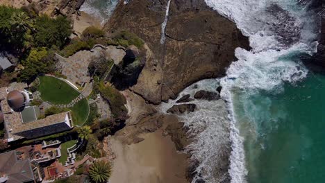 Aerial-view-looking-down-on-cliff-side-housing,-on-the-edge-of-the-Pacific-Ocean