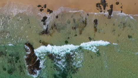 Aerial-shot-of-waves-breaking-on-tropical-beach