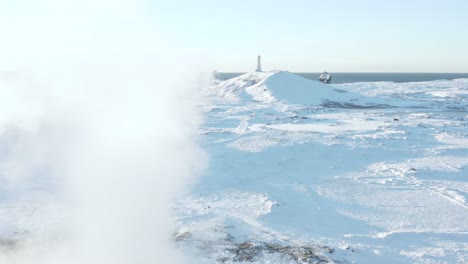 Flying-past-steam-from-Gunnuhver-geyser-towards-iconic-Reykjanes-Lighthouse