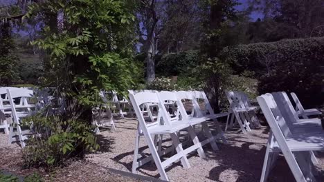 Weiße-Stühle,-Die-In-Reihen-In-Einem-Garten-Für-Hochzeiten-Angeordnet-Sind