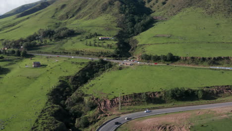 Aerial---winding-road-and-green-hills,-Tafi-del-Valle,-Argentina,-wide-backward