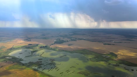 Aerial-backward-flight-over-the-farm-fields-and-wetlands-during-the-storm