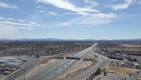 Aerial-view-of-the-suburbs-and-US-95-in-Las-Vegas,-Nevada,-wide-shot-lowering