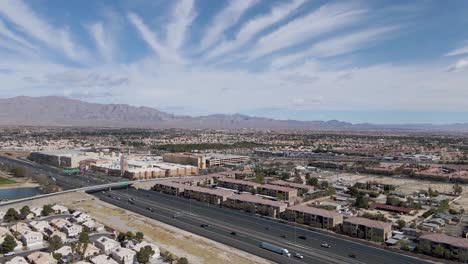 Slow-aerial-forward-of-Traffic-on-Highway-in-Summerlin-Cityscape,-suburb-of-Las-Vegas-during-beautiful-sunny-day