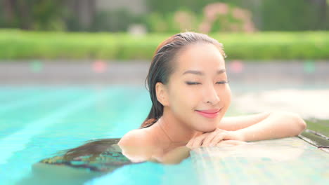 Porträt-Einer-Jungen-Asiatischen-Frau-Mit-Perfekter-Gesichtshaut,-Die-Sich-Im-Schwimmbad-Entspannt
