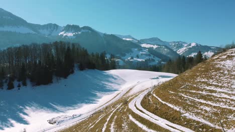 4K-UHD-aerial-drone-flight-moving-above-snowy-hills-and-tree-tops-in-the-Bavarian-Alps-in-winter-in-Germany,-close-to-Austria