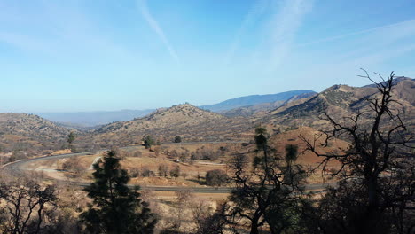 View-of-the-Tehachapi-Loop-on-a-clear-day---sliding-aerial-perspective-with-trees-in-the-foreground