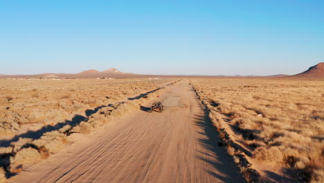 Un-Vehículo-Todoterreno-O-Un-Buggy-Conduciendo-Por-Un-Camino-De-Tierra-En-El-Desierto-De-Mojave---Vista-Aérea