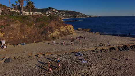Aerial-drone-view-of-people-enacting-on-a-beach-in-California