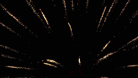 Close-up-view-of-fireworks-bursting-into-colorful-sparkling-light-in-the-night-sky