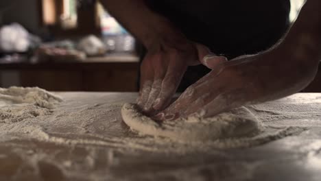 4K-Male-chef-kneading-homemade-pizza-dough-on-wooden-table-3