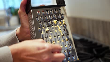 Close-up,-hands-of-female,-grating-cheese-with-metal-grater