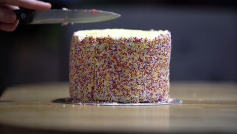 Hand-cuts-delicious-rainbow-cake-with-steel-knife