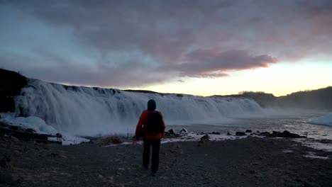 Hombre-Con-Mochila-Camina-Hacia-La-Cascada-De-Faxi-En-Islandia