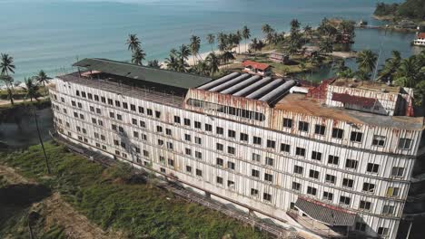 Drone-monitoring-roof-top-of-an-ocean-hotel-resort-building,-top-view-of-the-drone-over-the-roof-of-old-land-locked-ferry