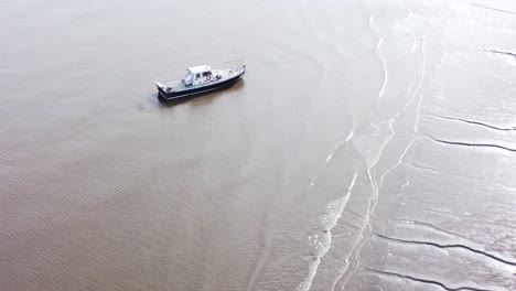 Aerial-view-sailing-boat-floating-on-shimmering-ocean-tide-waves-pull-back