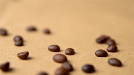 Coffee-beans-falling-from-above-on-old-paper-slow-motion