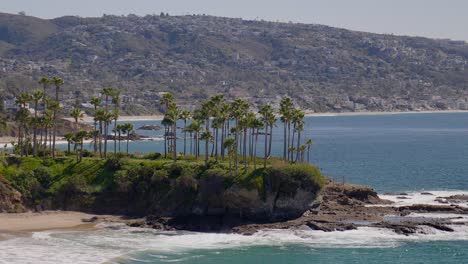 Rock-Peninsula,-full-of-palm-trees,-sticking-out-into-the-Pacific-Ocean