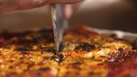 Cutting-with-knife-hot-smokey-delicious-homemade-pizza-in-wooden-table-close-up-Slow-Motion-60FPS