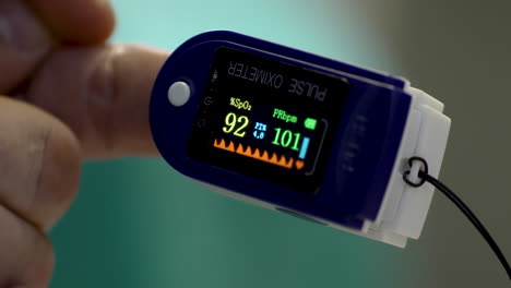 Pulse-oximeter-working-on-a-male's-hand-in-the-medical-center-before-Covid-19-vaccination
