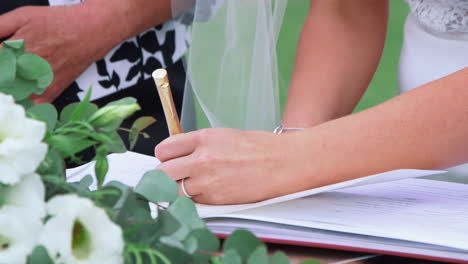 Bride-Signing-Marriage-License-Or-Wedding-Contract---high-angle,-close-up