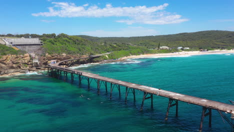 Catherine-Hill-Bay-pier,-NSW-Australia-coastline,-aerial-reveal