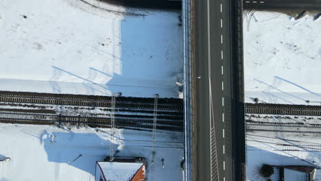 Top-View-Of-Flyover-Bridge-With-Road-And-Train-Tracks-In-Snowy-Land-On-A-Winter-Sunny-Day-In-Rakowice,-Krakow,-Poland