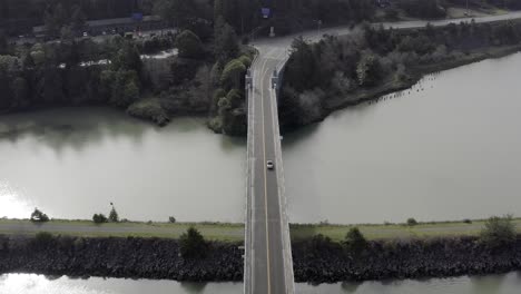 Aerial-over-Bridge,-tracking-car-over-river,-Gold-Beach,-Oregon