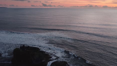 aerial-bali-hindu-famous-temple-tanah-lot-over-the-ocean-during-epic-sunset,-travel-destination