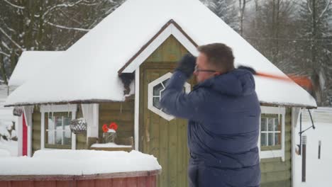 Man-trying-to-break-ice-with-a-big-hammer-in-a-snowed-cold-environment