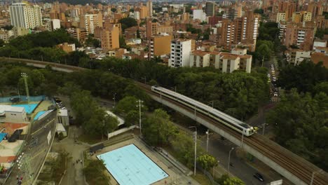 Aerial-View-of-Medellin-Metro-Train-with-Buildings-in-Background