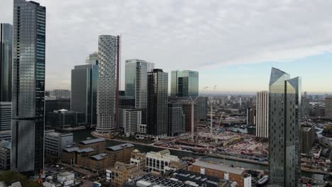 Aerial-shot-of-building-freeze-on-construction-site-in-the-middle-of-skyscrapers-of-financial-district-in-London