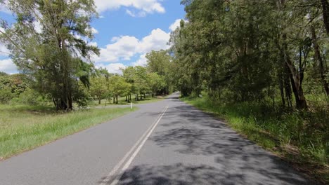 Rear-facing-driving-point-of-view-POV-of-deserted-Queensland-shady-rural-lanes-In-the-Glasshouse-Mountains---ideal-for-interior-car-scene-green-screen-replacement