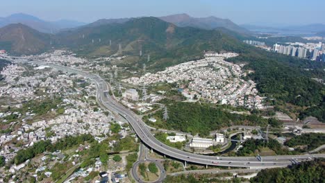 Luftaufnahme-Des-Wohngebiets-Am-Rande-Von-Hongkong-Mit-Verbindungsautobahn-Und-Umliegenden-Berghängen