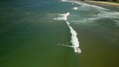 Aerial-view-of-a-surfer-paddling-and-riding-a-small-wave-on-the-tropical-island-of-Trinidad