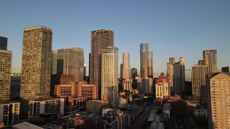 Aerial-Trucking-Shot-Der-Städtischen-Skyline-Im-Berühmten-Bankenviertel-Namens-Canary-Wharf-Während-Des-Sonnenuntergangs
