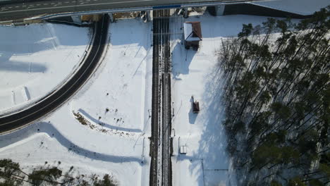 Bird's-Eye-View-Of-Roads-And-Railways-In-Countryside-Landscape-During-Winter-In-Rakowice,-Krakow,-Poland---aerial-drone-shot