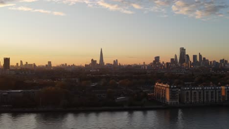 Aerial-trucking-shot-of-doubletree-hilton-hotel-and-central-skyline-of-London-during-sunset-in-background