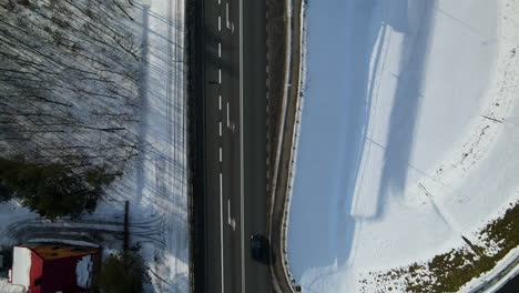 Asphalt-Highway-Against-Snowy-Field-On-A-Sunny-Day