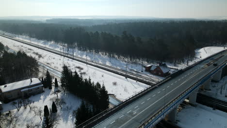 Leichter-Verkehr-Auf-Der-Überführungsbrücke-Während-Des-Sonnigen-Wintertages-Mit-Wäldern-Im-Hintergrund-In-Rakowice,-Polen