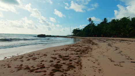 Walking-down-a-stunningly-beautiful-beach-with-golden-sand,-blue-water,-and-palm-trees-on-the-tropical-beach-of-Tabatinga-near-Joao-Pessoa-in-Paraiba,-Brazil