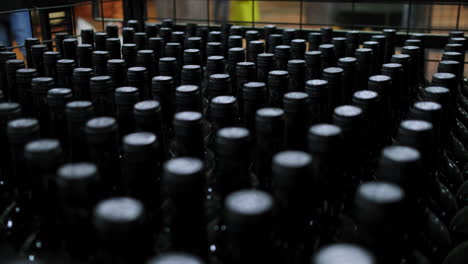 Nahaufnahme-Der-Spitzen-Von-Weinflaschen,-Die-In-Einer-Weinfabrik-Aufgereiht-Sind