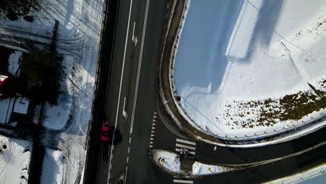 drone-top-down-road-crossing-during-winter,-road-crossing-at-the-railway-viaduct