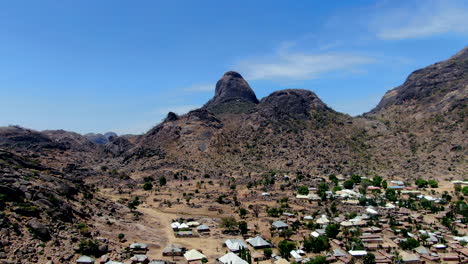 A-suburb-of-the-city-of-Dass-nestled-beneath-the-rugged-mountains-of-the-Nigerian-state-of-Bauchi---aerial-pull-back-view