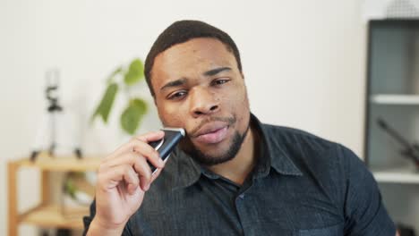 Cute-african-man-shaving-with-a-shaver