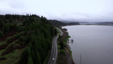 Aerial-View-Of-Oregon-Route-42-Connecting-Coos-Bay-And-Coquille-In-Oregon-With-Flooded-Pasture-Next-To-Asphalt-Highway-After-The-Rain