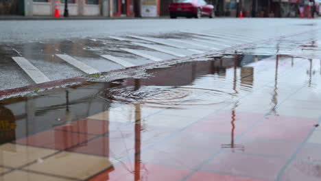 Vehicles-Reflection-in-Puddles-On-Sidewalk