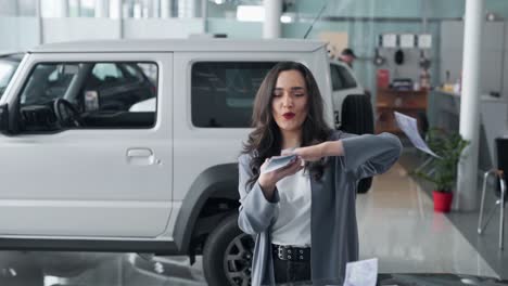 Beautiful-young-woman-scattering-money-in-a-car-dealership