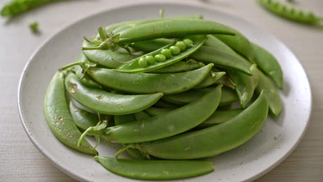 fresh-sweet-green-peas-on-white-plate