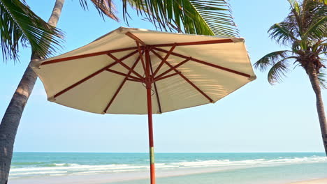 A-canvas-beach-umbrella-offers-shade-on-a-tropical-beach